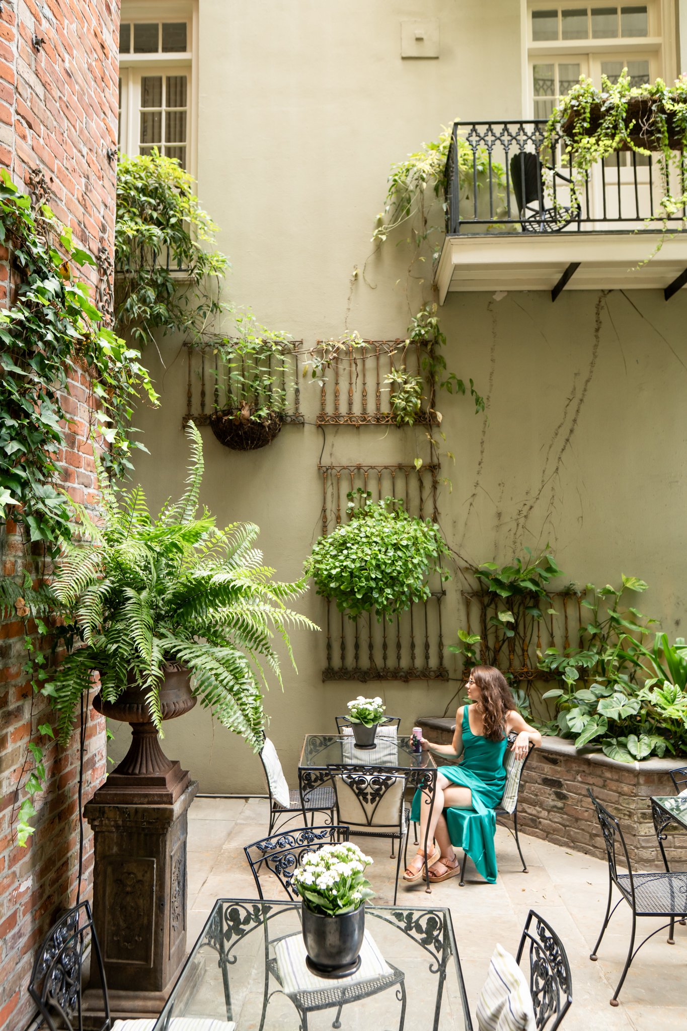 Woman sitting in a outdoor courtyard in a blue dress