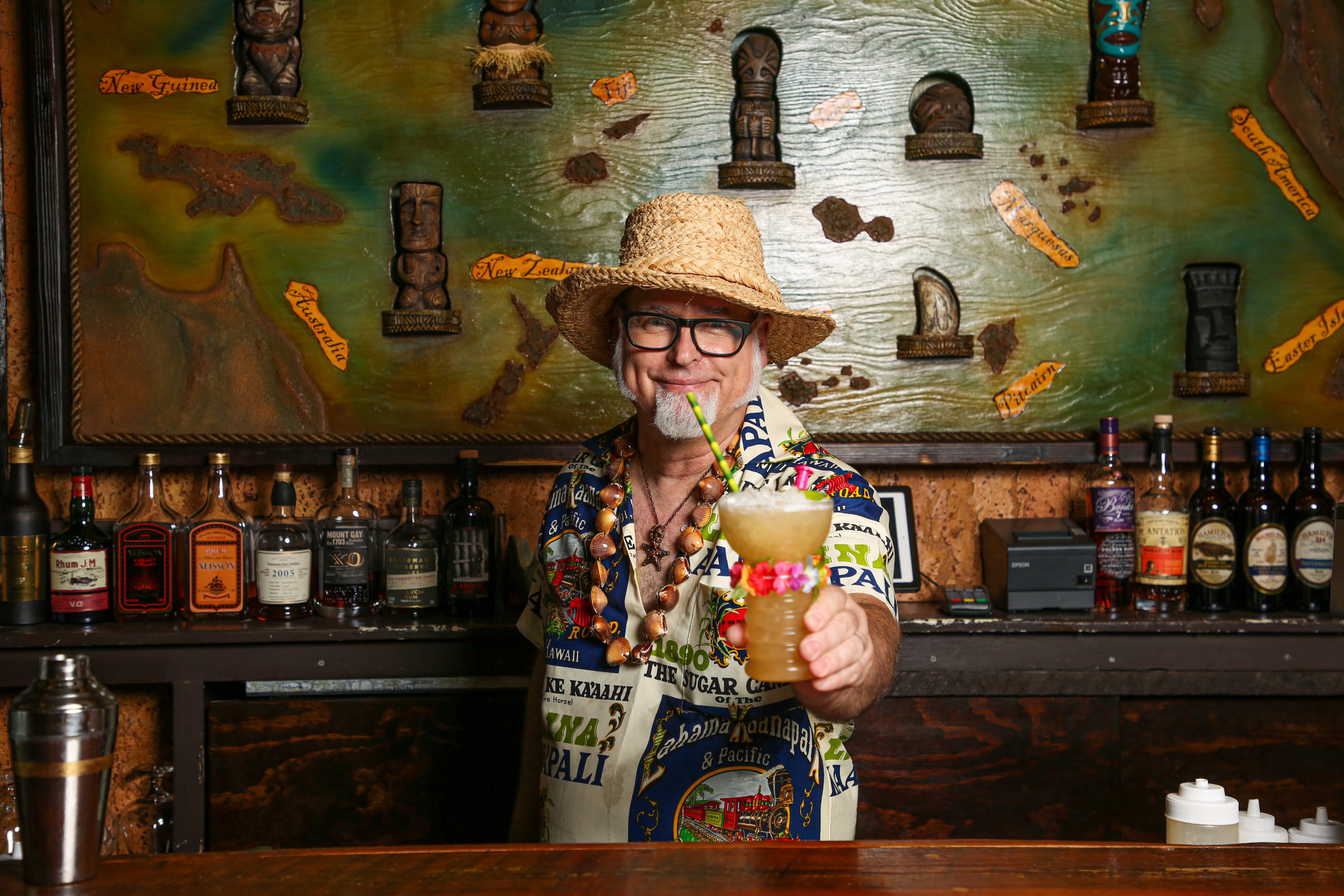 a man in a hat holding a drink