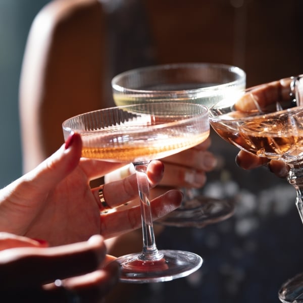 Unrecognizable group of multi-ethnic peoples having fun together at Christmas party and toasting with alcohol.