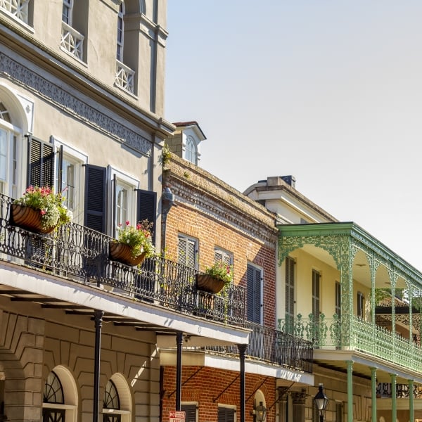 New Orleans, Louisiana in Mardi Gras Carnival Celebrations. New Orleans French Quarter architecture showcasing colorful balconies with intricate ironwork and blooming flowers, capturing the charm of this historic neighborhood