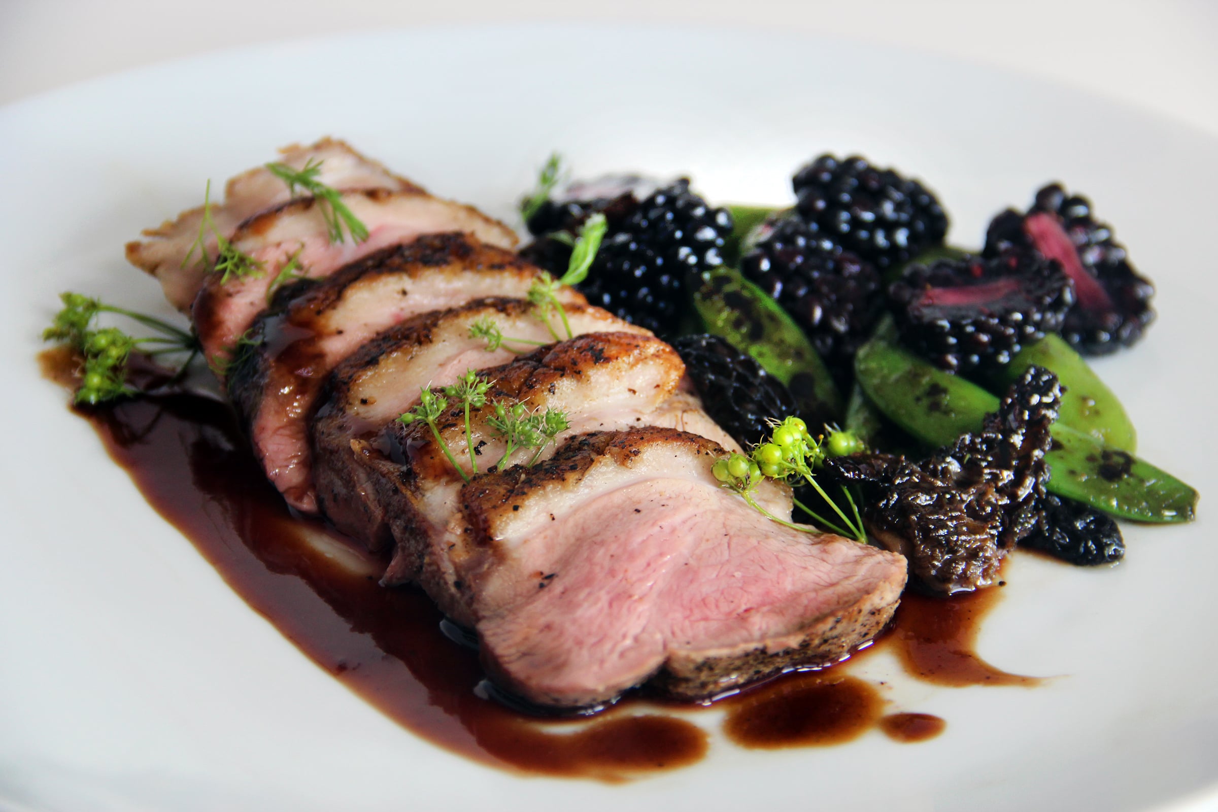 a plate of sliced meat and vegetables