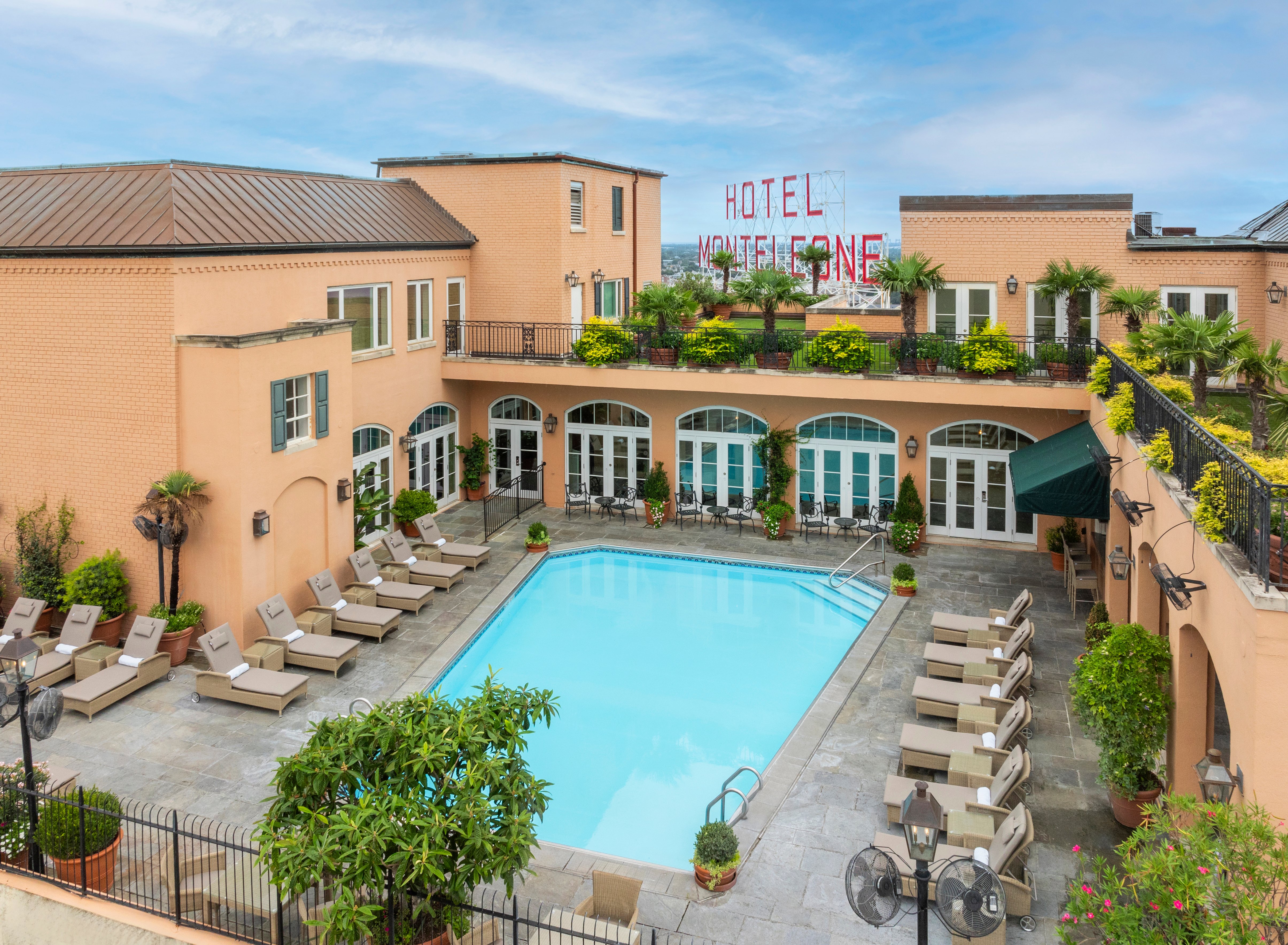 A hotel pool area with lounge chairs and palm trees
